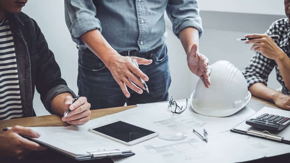 Photo de plusieurs personnes qui travaillent sur des documents de chantier